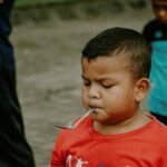 a young boy with a spoon in his mouth