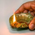 a person holding a small candle in their hand